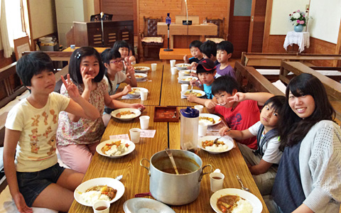日曜学校 教会で皆と一緒にカレーライスを食べる子どもたちの様子
