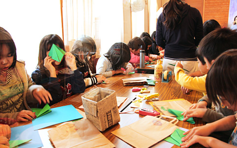 日曜学校 子どもクリスマス会でクリスマスツリーを折り紙で作る子供たち